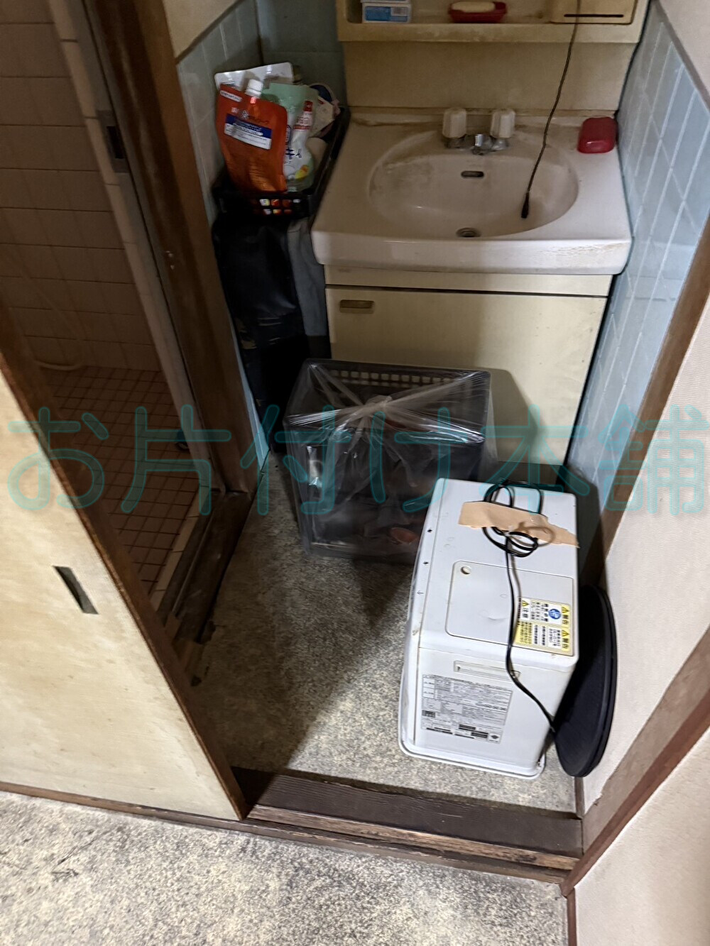 お片付け本舗による西成区での遺品整理の事例。片付ける前の物が置いてある洗面所のBefore。