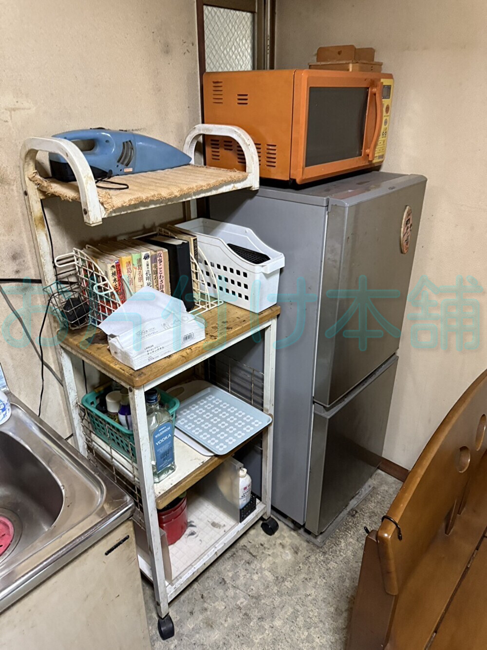 お片付け本舗による西成区での遺品整理の事例写真。片付ける前の冷蔵庫やレンジ台が置いてあるキッチンのBefore