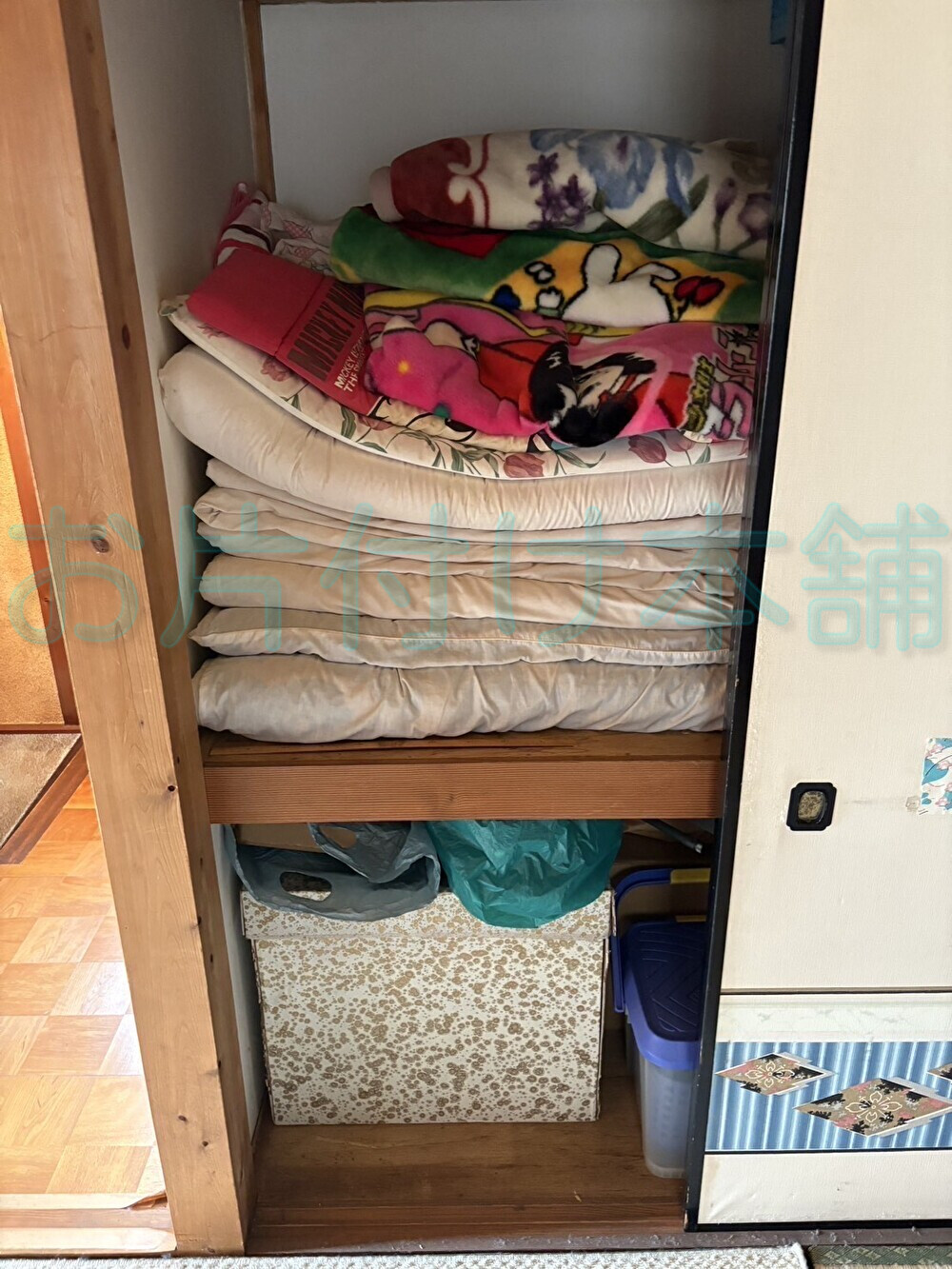お片付け本舗による大津市のお片付け事例。布団や座布団が入っている片付け前の押入れ。