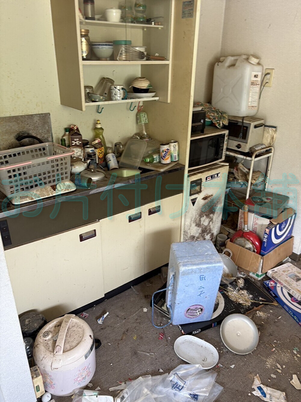 お片付け本舗による、滋賀県守山市での遺品整理の事例。調味料や調理器具がキッチンを埋め尽くし、床にまで散乱している。