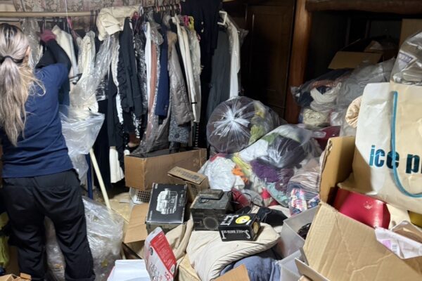 お片付け本舗による阿倍野区でのお片付けの事例。服が大量に積み上げられている部屋のBefore