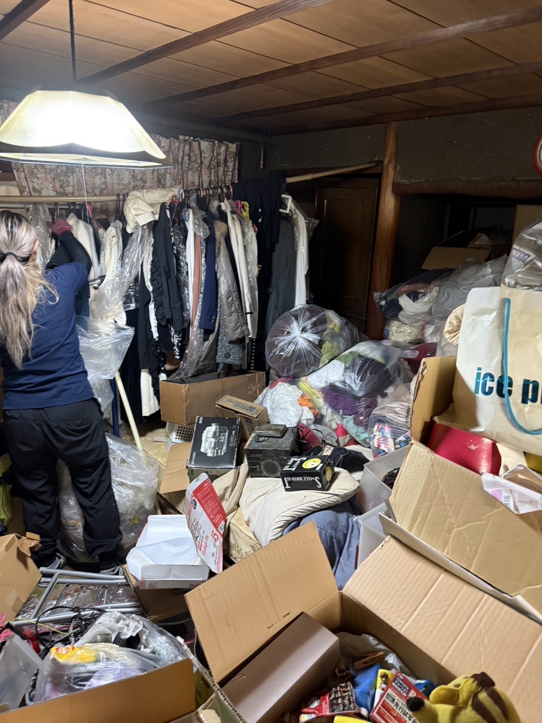 お片付け本舗による阿倍野区でのお片付けの事例。服が大量に積み上げられている部屋