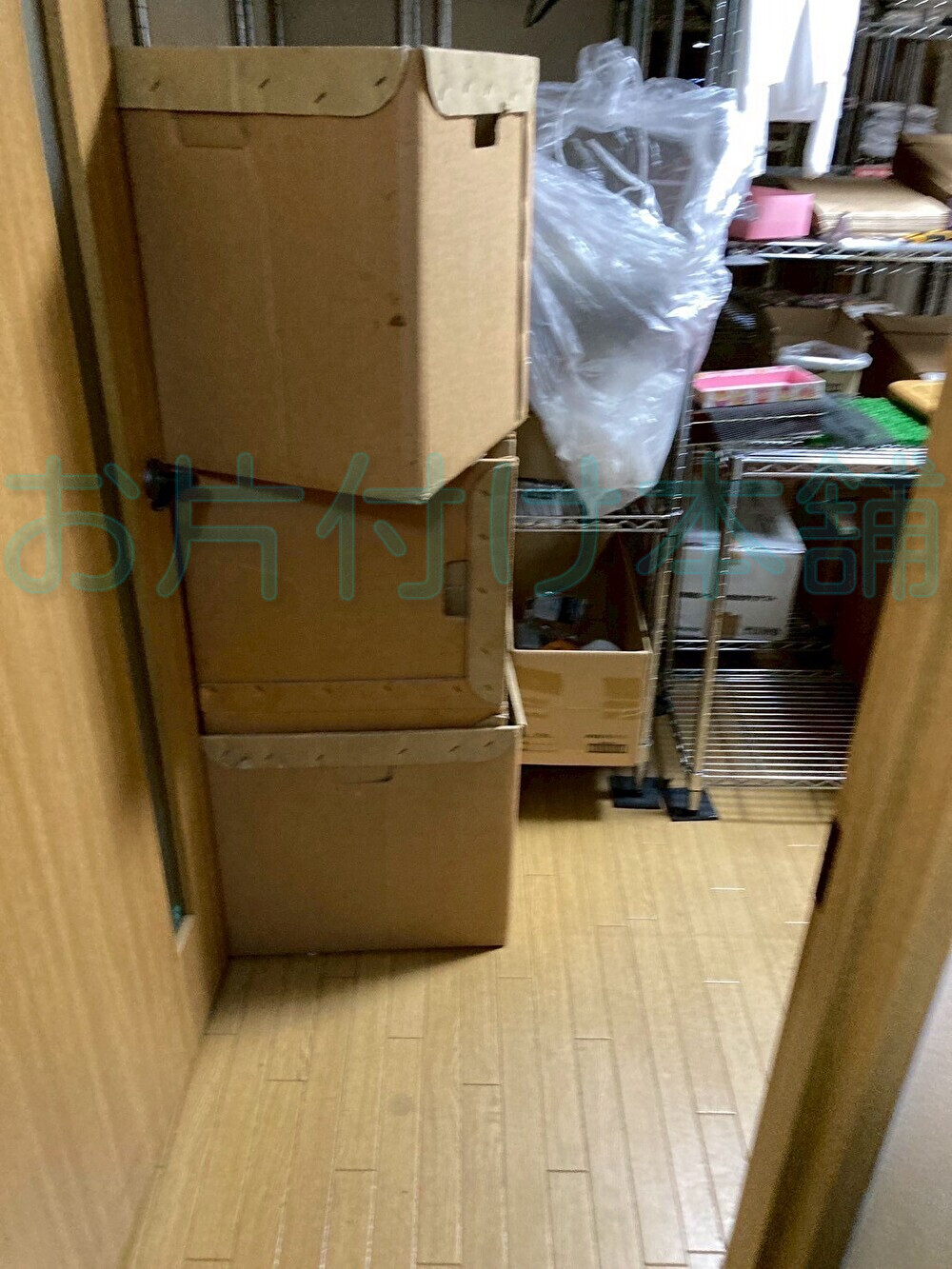 お片付け本舗によるお片付けの事例。片付ける前のスチールラックと大きい段ボールが３つ積み上げられている。